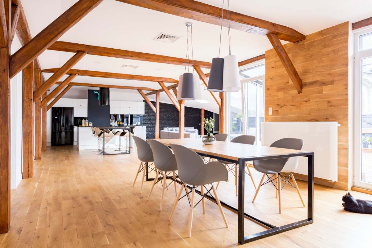 Grey chairs at dining table with decorative vase in spacious wooden dining room